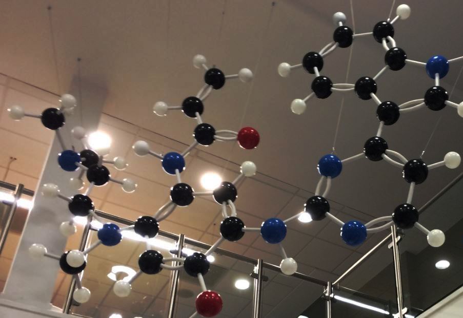 A giant molecular model of a new drug suspended from the ceiling in a large room