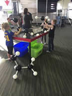 Children playing with giant molecular models in a museum